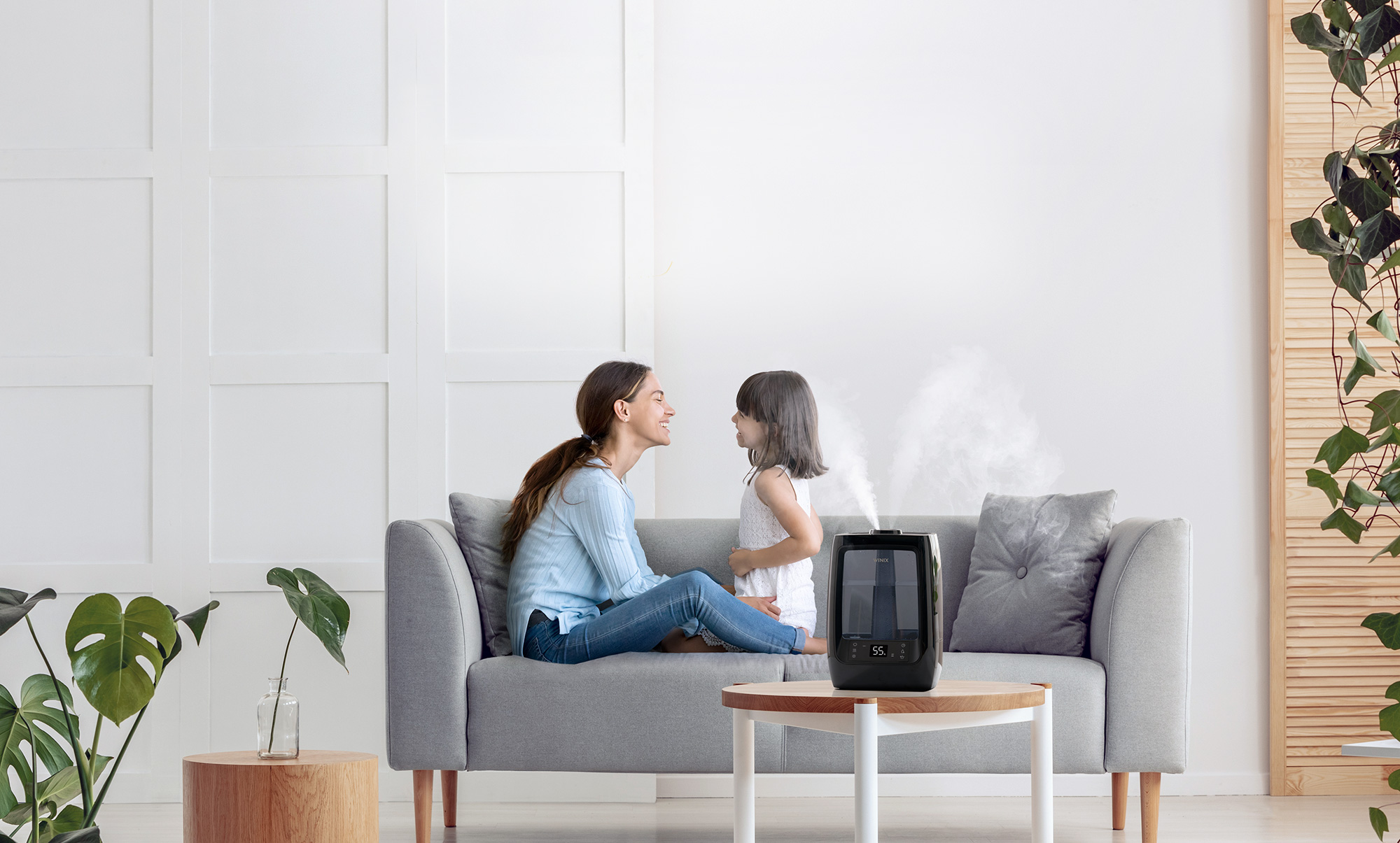 L200 Humidifier on side table next to woman and young child sitting on a couch